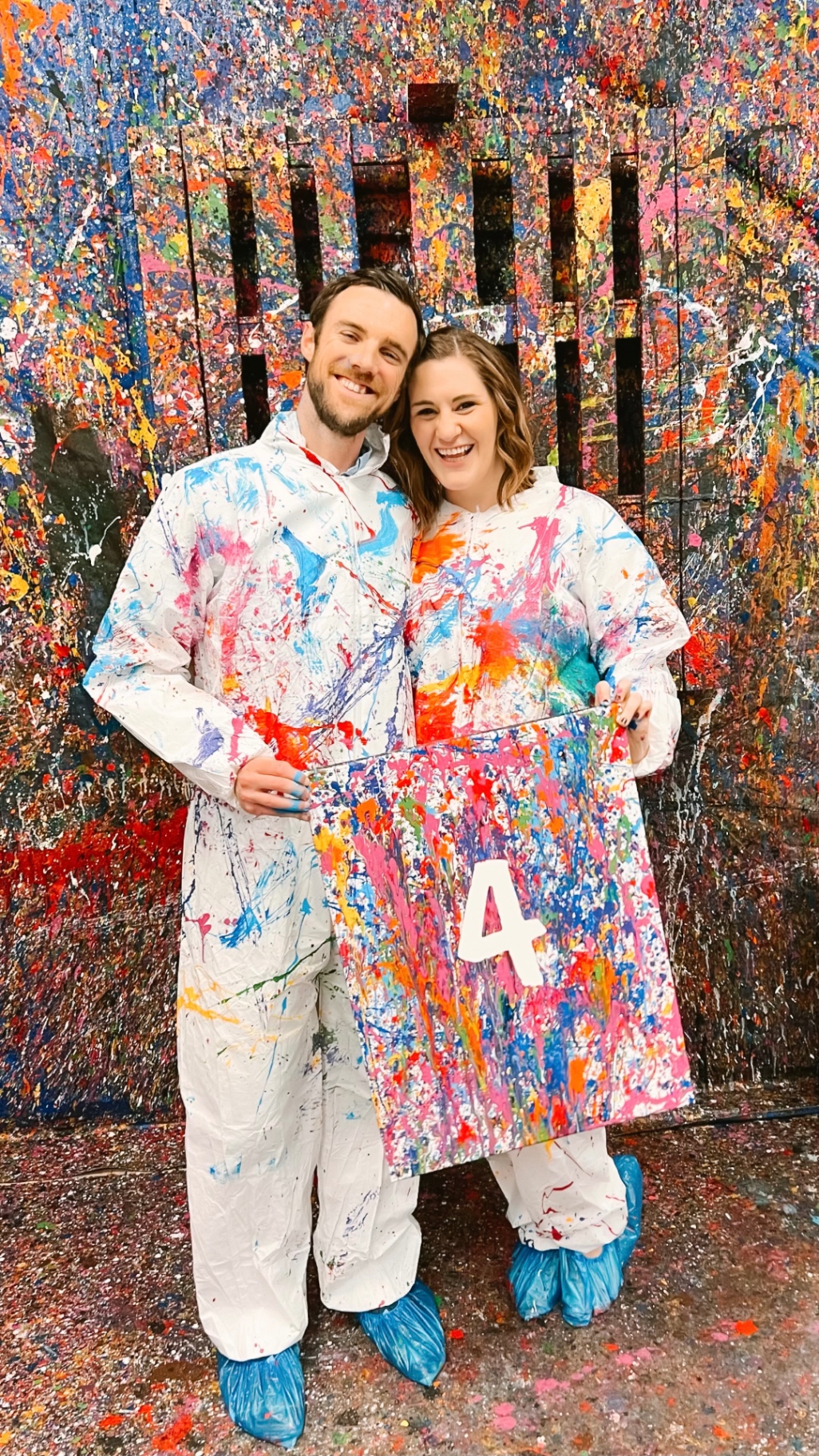 Two painters holding a finished splatter canvas